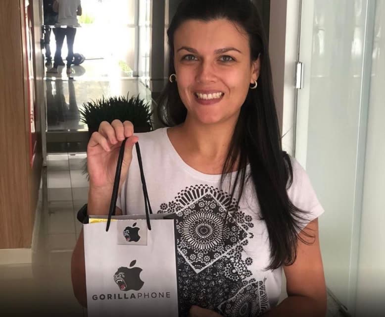Cliente da Gorillaphone com a sacola da loja e o iPhone